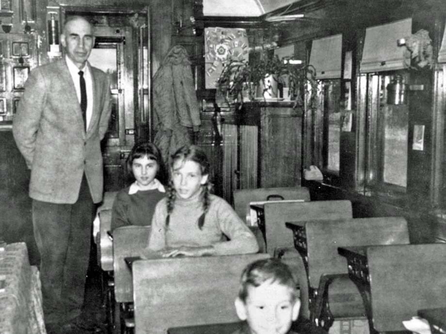 Teacher Bill Wright with students on the school car.