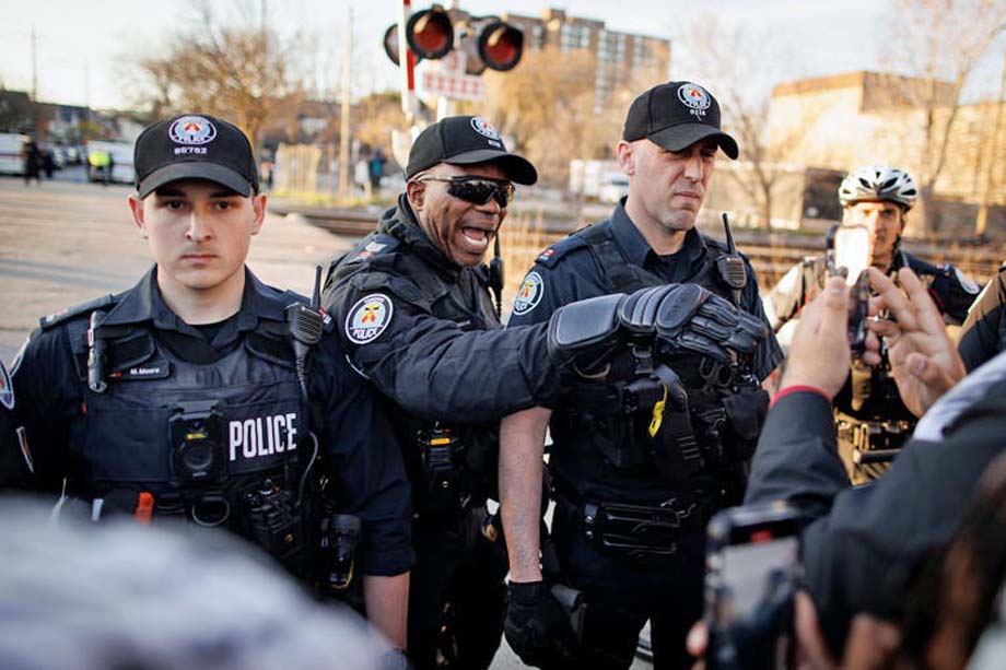 Toronto police face protesters.