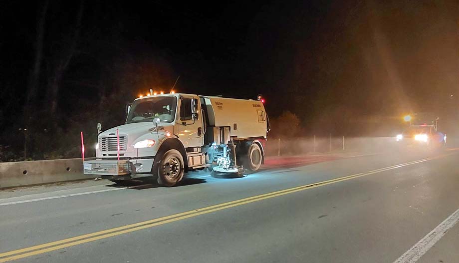 The street sweeping vehicle.