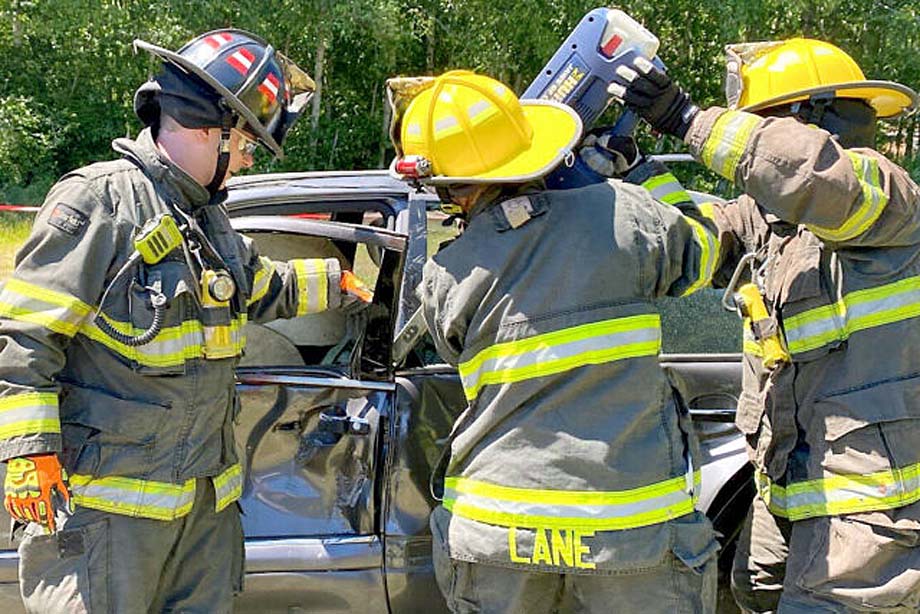 Firefighters practice using vehicle extraction equipment.