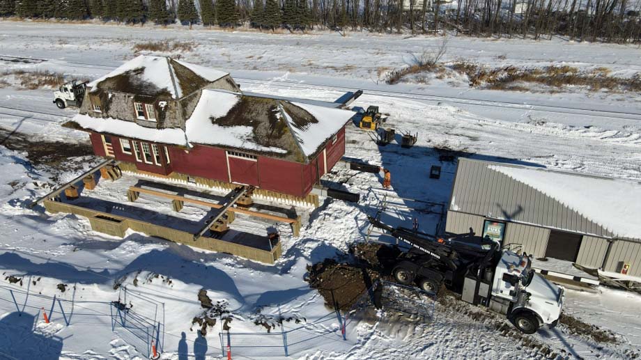 The La Riviere station at it's new location in Manitou on Main Street next to an active railway.